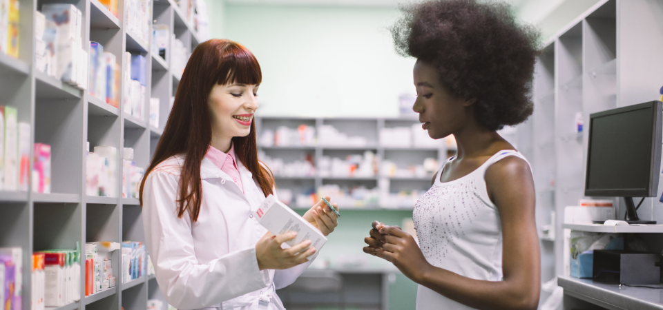 female pharmacist talking to senior customer
